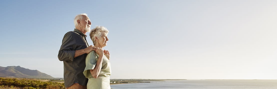 Senior couple enjoying the view on wooden terrace at the sea