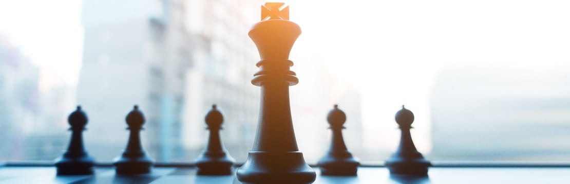 Chess pieces in front of an urban skyline